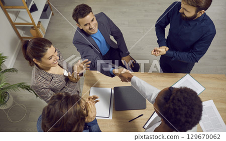 Happy man receives reward for professional achievement during work meeting in office. Happy man receives reward for professional achievement during work meeting in office. 129670062