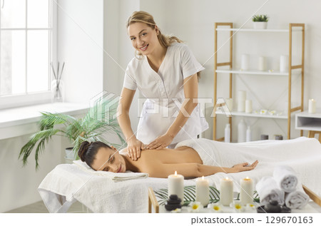 Massage female therapist doing relaxing aromatics massage oil pleasure, stimulating skin health Massage female therapist doing relaxing aromatics massage oil pleasure, stimulating skin health 129670163