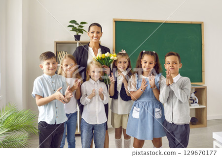 Festive portrait of elementary school children and their female teacher in school classroom. Festive portrait of elementary school children and their female teacher in school classroom. 129670177