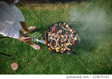 Delicious barbecue gathering with grilled vegetables and sausages on a sunny afternoon Delicious barbecue gathering with grilled vegetables and sausages on a sunny afternoon 129670187