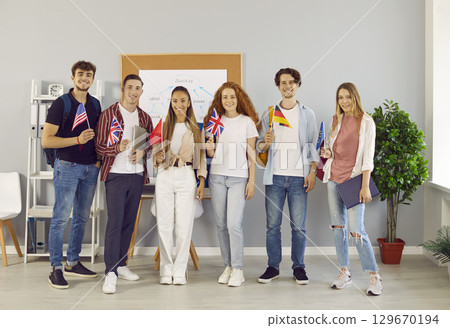 Portrait of happy international students holding flags of different countries in their hands. 129670194