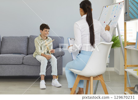 Art therapy, doctor with young patient are looking for associations with simple drawings. Art therapy, doctor with young patient are looking for associations with simple drawings. 129670231