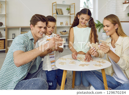 Happy parents play with their daughter and son. 129670284