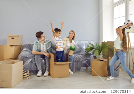 Active joyful children enjoy moving day and play, have fun and fool around in new house. 129670314