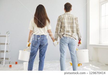 Couple Holding Hands And Dreaming During Home Renovation And Painting 129670414