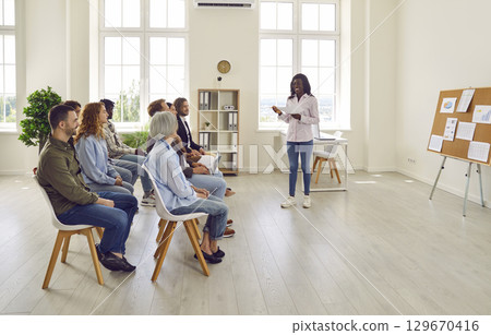 Group of business people on a meeting discussing work project sitting on chairs in office. Group of business people on a meeting discussing work project sitting on chairs in office. 129670416