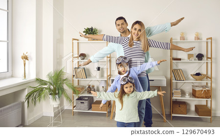 Happy little children together with their parents playing and flying planes at home 129670493