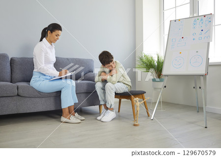 Therapist or psychologist trying to communicate with sad, depressed school child 129670579