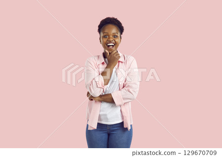 Cheerful young African American woman gets happy when she thinks of a very good idea Cheerful young African American woman gets happy when she thinks of a very good idea 129670709