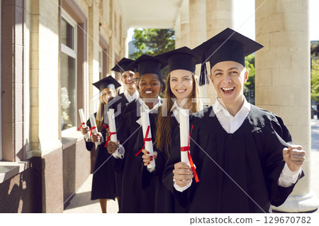 College graduates standing behind each other and smiling 129670782