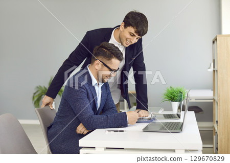Two business colleagues analyzing strategy discussing financial planning schedule and company budget 129670829