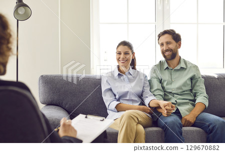 Cheerful smiling married man and woman are having a psychotherapy session together Cheerful smiling married man and woman are having a psychotherapy session together 129670882
