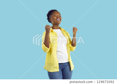 Happy, excited young woman celebrating success and having fun isolated on blue background 129671092