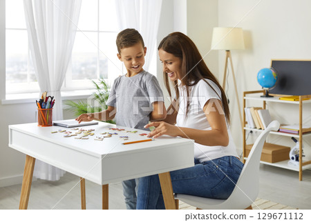Smiling mom and son playing board game at home 129671112