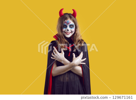 Portrait of teen girl with creative Halloween skull makeup 129671161