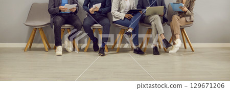 Legs of various people sitting in row in waiting room before interview or business meeting. Legs of various people sitting in row in waiting room before interview or business meeting. 129671206