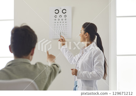 Ophthalmologist Or Optometrist Checking A Patient Vision In A Clinic 129671212