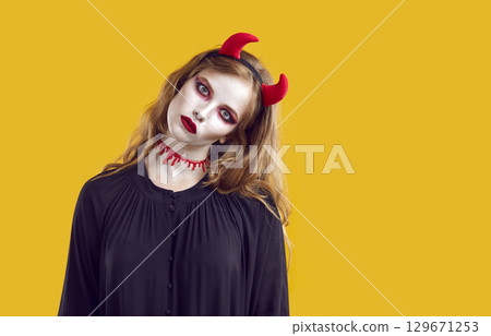 Portrait of creepy woman looking at you with creepy look on Halloween on orange background. 129671253