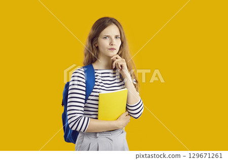 Portrait of thoughtful girl student with doubtful and skeptical facial expression. 129671261