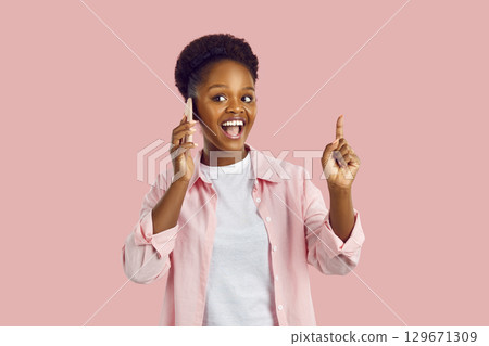 African American woman emotionally talking on smartphone. 129671309