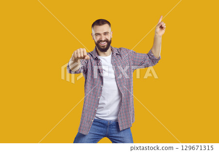Happy excited magnificent bearded man 30s years old wears plade shirt pointing finger up on workspace area. Happy excited magnificent bearded man 30s years old wears plade shirt pointing finger up on workspace area. 129671315