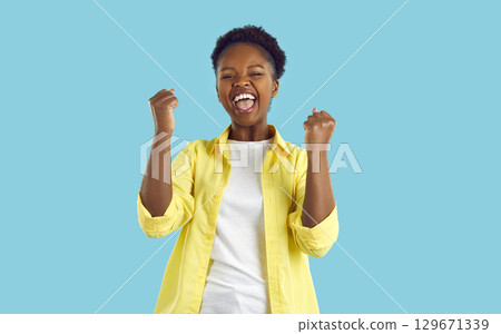 Happy excited emotional african american woman sincerely happy isolated on light blue background. Happy excited emotional african american woman sincerely happy isolated on light blue background. 129671339
