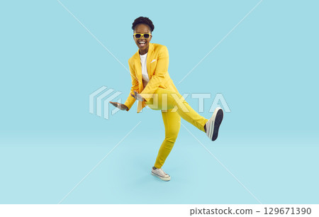 Cheerful, positive and energetic african american woman dancing with funny crazy expression. 129671390