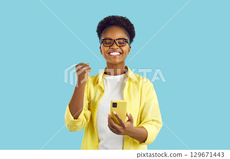 Excited african lady with smart phone. Indoor communication concept 129671443