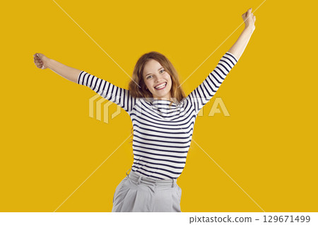 Happy excited young woman having fun rejoicing in good news, success or achievement. 129671499