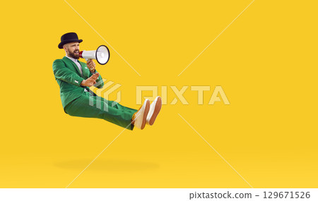 Man in green suit makes announcement in honor of St. Patrick's Day using megaphone. Man in green suit makes announcement in honor of St. Patrick's Day using megaphone. 129671526