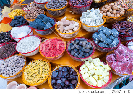Traditional spices market. Pots and wooden tubs stand in row with colorful tea, spices, fruits, roots, flowers. Street bazaar. Dubai, UAE.  129671568
