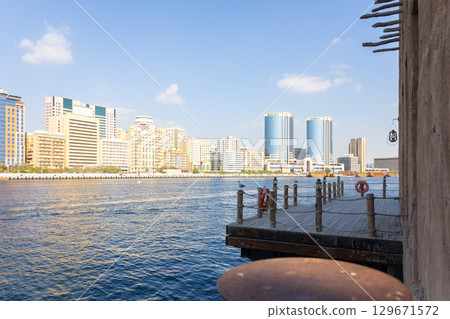 Old town in Al Seef Cultural Historical District. Beautiful view of water, old houses and new ones of Dubai Creek, Dubai, UAE. Taken off hand. High quality photo 129671572