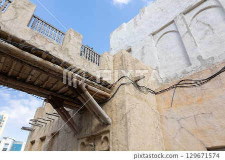 Old town in Al Seef Cultural Historical District on shores of Dubai Creek. Tourist place with old streets, houses and shops, Dubai, UAE 129671574