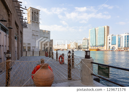 Old town in Al Seef Cultural Historical District. Beautiful view of water, old houses and new ones of Dubai Creek, Dubai, UAE. Taken off hand. High quality photo 129671576