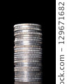 Stack of silver coins with reeded edges. Twenty-eight circulated silver bullion coins, each of one troy ounce of 99.9 percent pure silver, stacked on top of each other, against black background. Photo 129671682