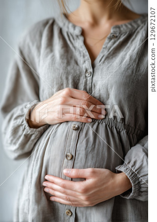 孕婦。一名年輕女子懷著嬰兒,手放在腹部 孕婦。一名年輕女子懷著嬰兒,手放在腹部 129672107