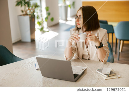 A Thoughtful Young Professional Working in a Modern and Inviting Workspace Environment 129673051