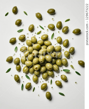 A vibrant cluster of green olives rests on a white surface, adorned with delicate leaves and glistening water droplets, showcasing their freshness and culinary appeal Generative AI A vibrant cluster of green olives rests on a white surface, adorned with delicate leaves and glistening water droplets, showcasing their freshness and culinary appeal Generative AI 129673222