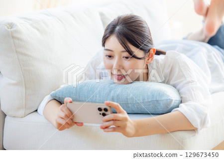 一個女人在客廳看視頻 129673450
