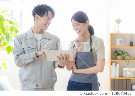 Men and women wearing work clothes discussing renovations 129673492