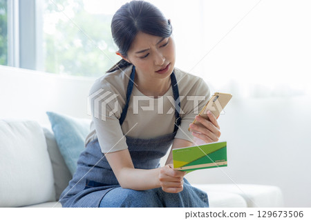 一個女人看著存摺時擔心 129673506