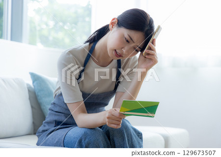 一個女人看著存摺時擔心 129673507