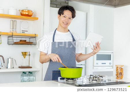 Young man standing in the kitchen 129673521