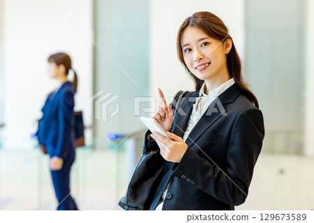 Business woman operating a smartphone in the office 129673589