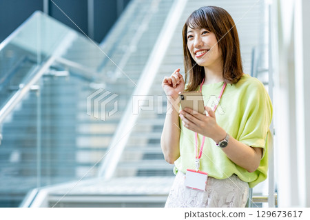 Business woman operating a smartphone in the office 129673617