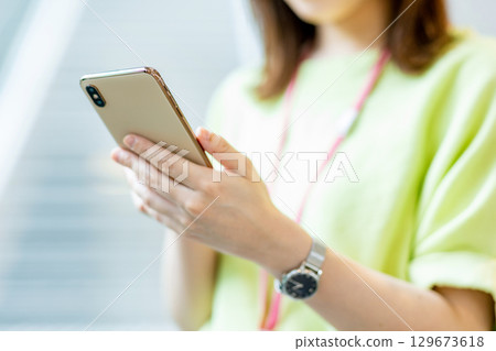Business woman operating a smartphone in the office 129673618