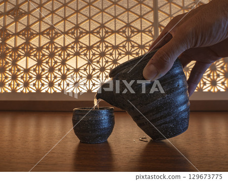 Sake poured into a Japanese vessel 129673775