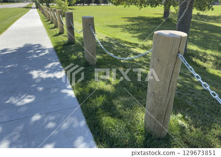 Wooden fence posts with metal chain 129673851