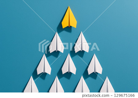 A yellow airplane leading a white triangular group against a blue background to symbolize strategic leadership A yellow airplane leading a white triangular group against a blue background to symbolize strategic leadership 129675166