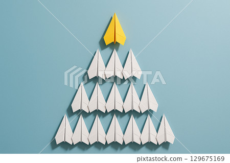 A yellow paper airplane leading a neat triangular pyramid of white airplanes as a clear symbol of leadership 129675169